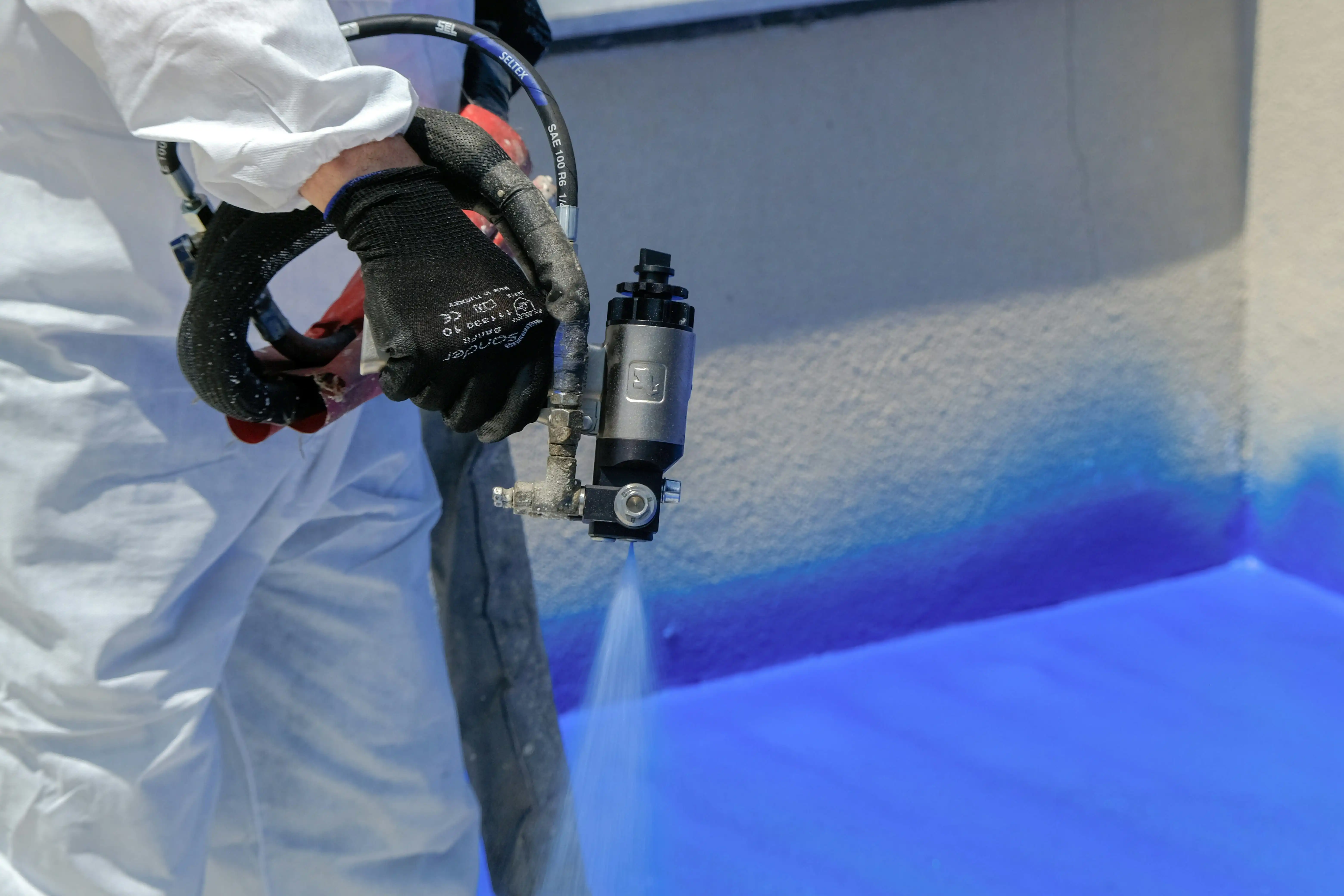 Spray foam insulation being applied with a professional spray gun during on-site installation